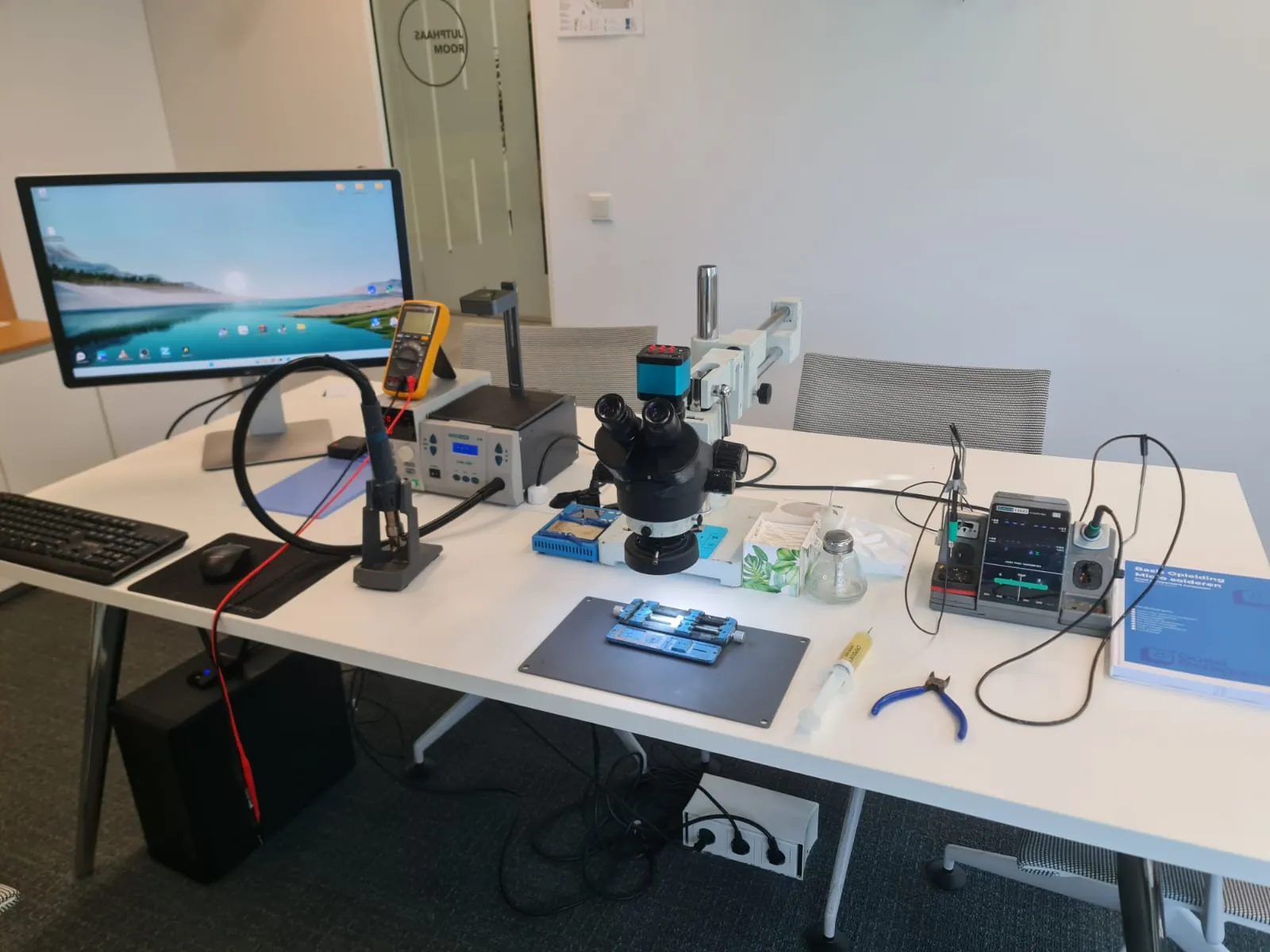 Ingerichte soldeerwerkplek met microscoop en soldeerstation