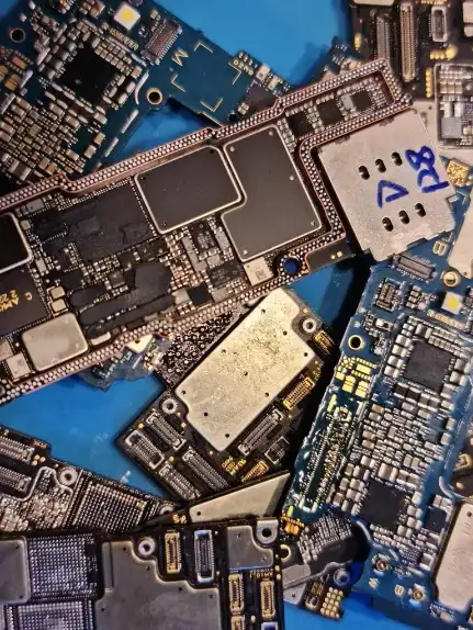 Losse smartphone-moederborden op een blauwe werkmat